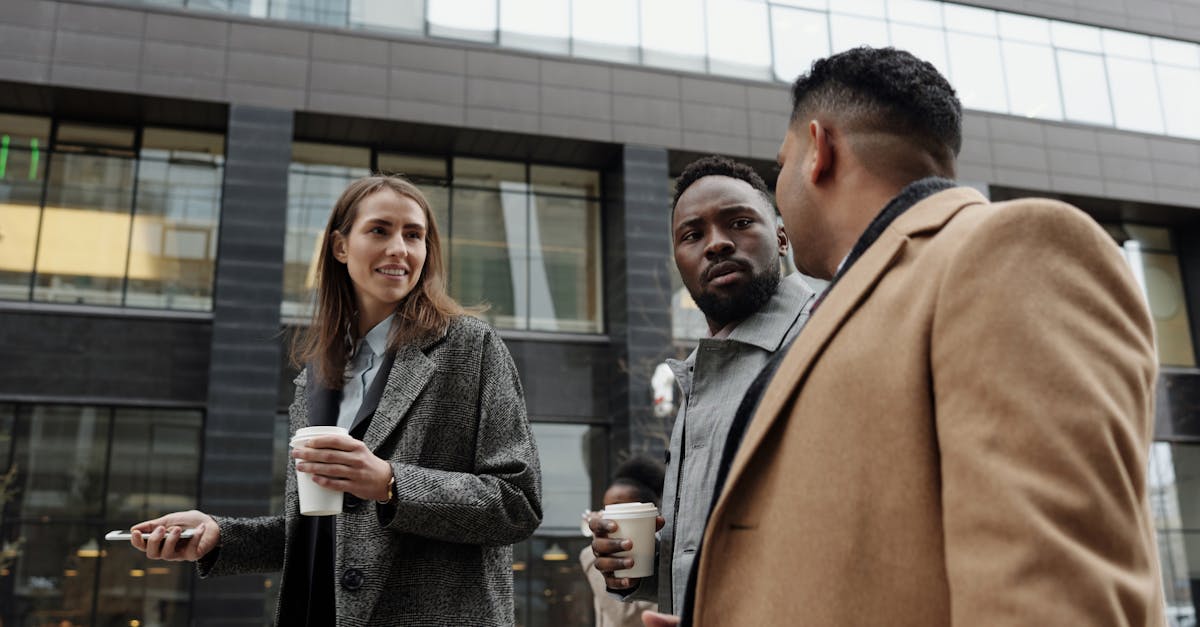 a group of diverse professionals discussing business during a coffee break outdoors